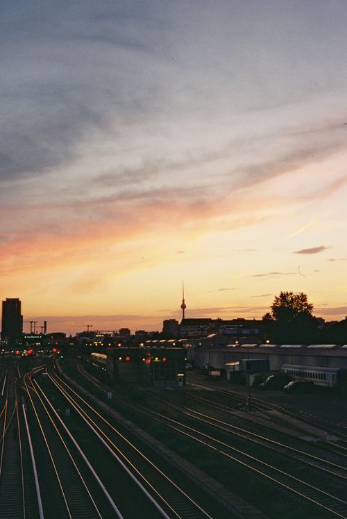 Free Scenic sunset view of Berlin railway tracks with the TV Tower in the background, capturing the vibrant urban landscape. Stock Photo