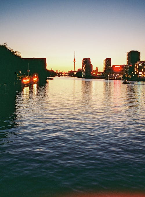 A sunset over the water with buildings in the background