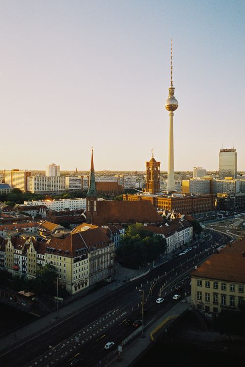 Free Scenic aerial view of Berlin's cityscape including the iconic TV Tower and Red City Hall at sunset. Stock Photo
