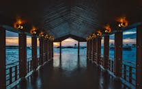 木制码头灯光明亮，俯瞰日落时宁静的海面，非常适合旅行和自然主题