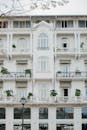 一座经典的白色历史建筑立面，配有阳台和绿化的详细视图