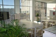 办公休息室宽敞明亮，配有白色桌椅，设计现代简约