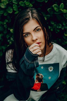 一位年轻女子的特写肖像，背景为绿色，展现了自然美景与休闲时尚