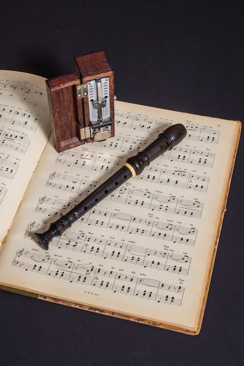 Free Brown Wooden Flute on Book With Notes Stock Photo