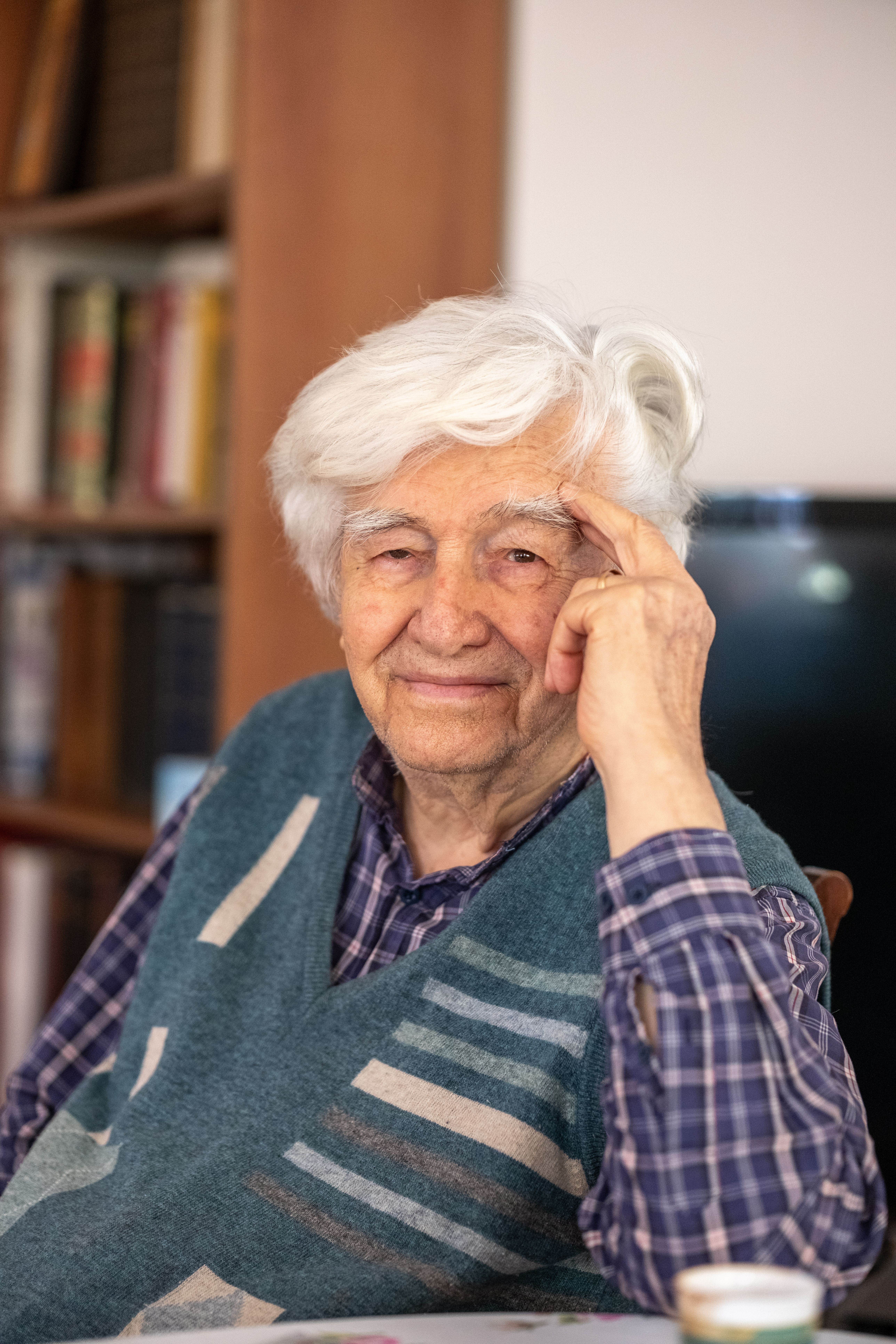 Portrait of a charming elderly man smiling warmly indoors, showcasing wisdom and joy.