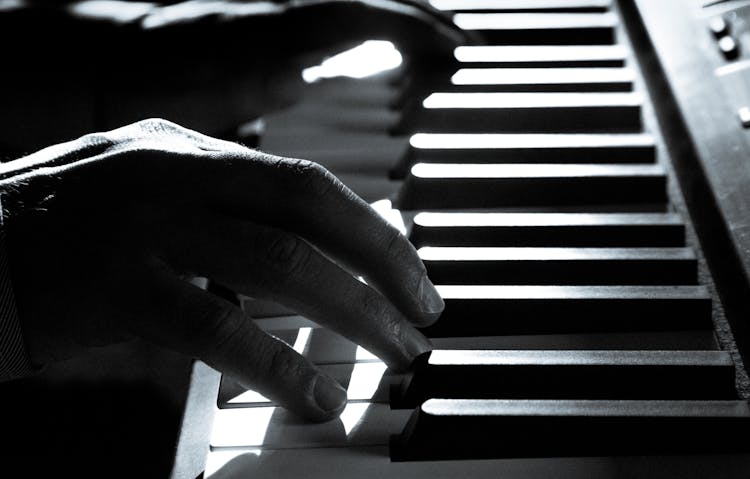 Grayscale Photo Of Person Playing Piano