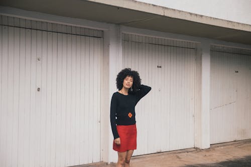 Donna In Camicia Nera A Maniche Lunghe In Piedi Fuori Dall'edificio