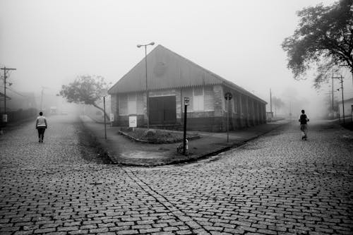 Fotografi Grayscale Dua Orang Berjalan Dengan Cara Berbeda