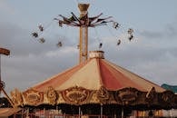 暮色中，游乐园的旋转木马和秋千在骑行，捕捉着热闹的节日气氛