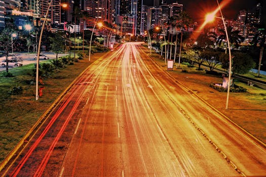 夜间，通过动态长时间曝光捕捉城市街道，呈现出充满活力的光径和城市天际线