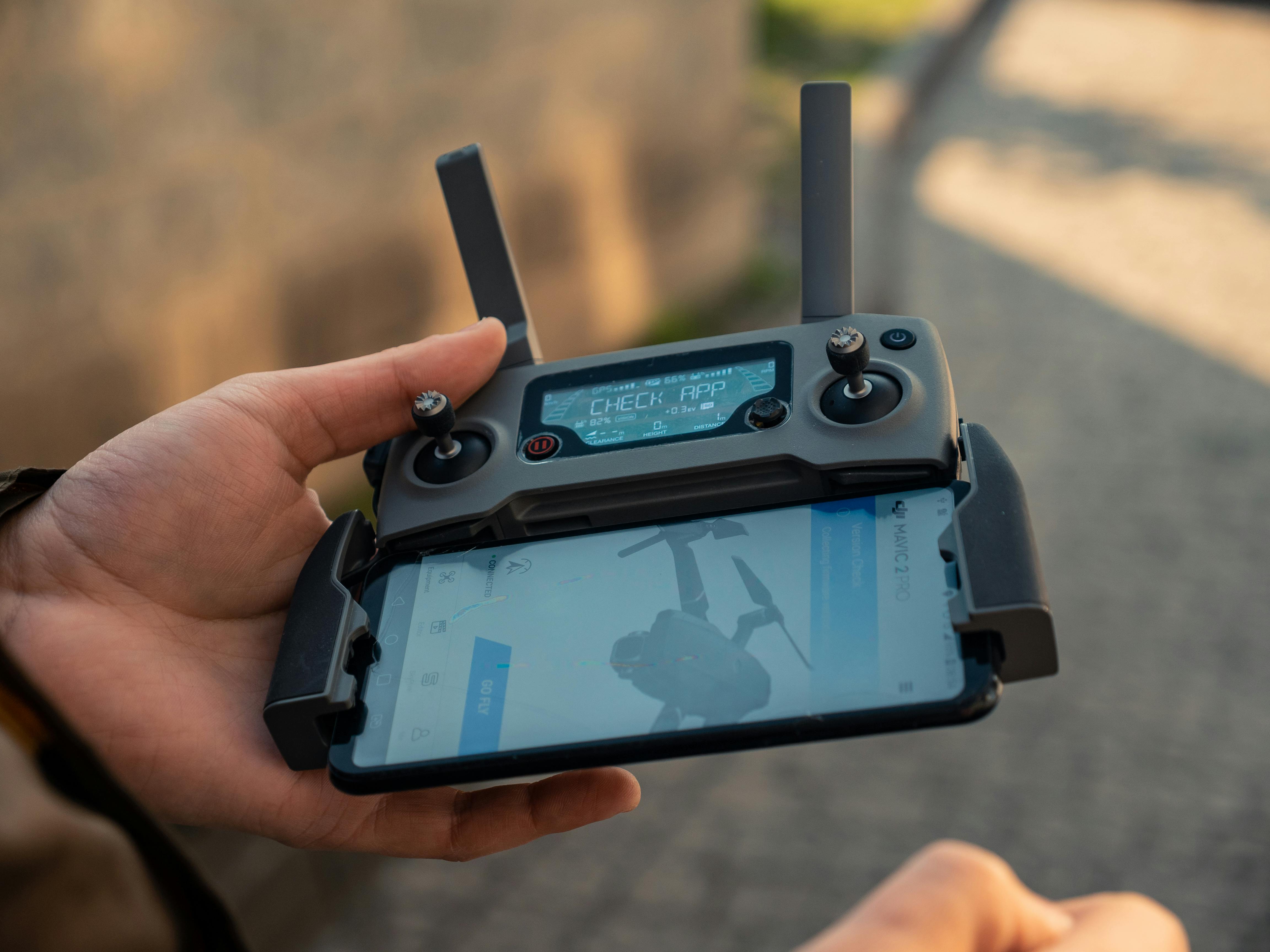 Person Holding Black Drone Controller