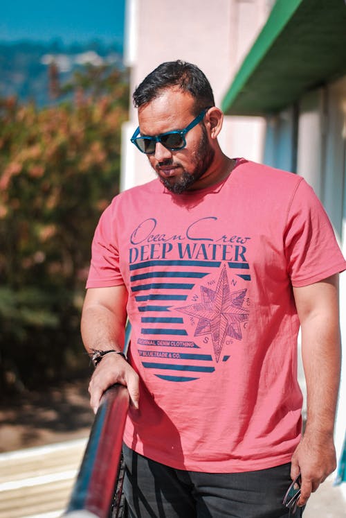 Shallow Focus Photo Of Man In Red Crew Neck T-shirt Wearing Sunglasses