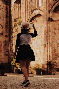 一名女子身着休闲装，在古老的砖砌废墟中探索，捕捉旅行与冒险的瞬间