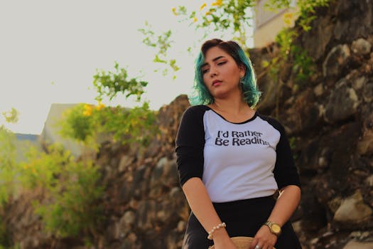 一位蓝发年轻女子穿着印有“我宁愿读书”字样的衬衫在户外摆姿势