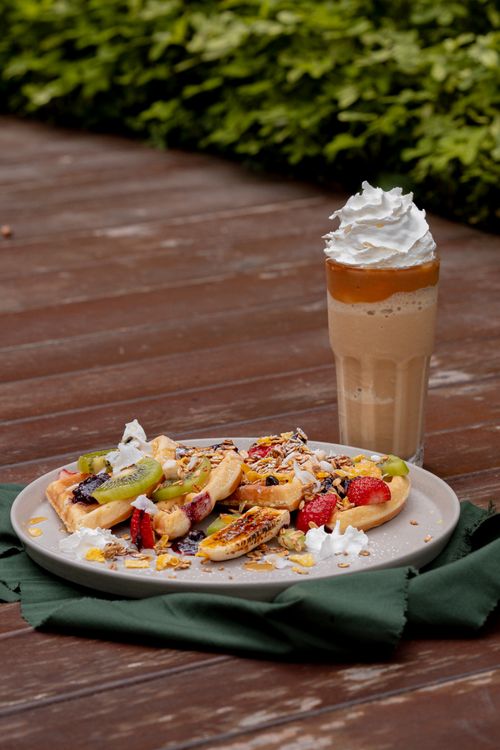 Free Savor the taste of fresh fruit and waffles paired with creamy whipped iced coffee, perfect for outdoor enjoyment. Stock Photo