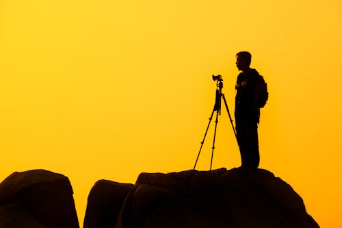 Free Man Standing on Rock Formation Stock Photo