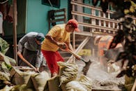 人们在建筑上积极工作，同时在户外将沙子铲进袋子里