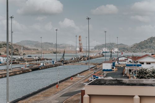 Free A panoramic daytime view of the Panama Canal locks with surrounding landscape and maritime infrastructure. Stock Photo