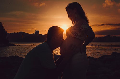 Ücretsiz Hamile Bir Kadının Göbeğini öpen Adamın Siluet Fotoğrafı Stok Fotoğraflar