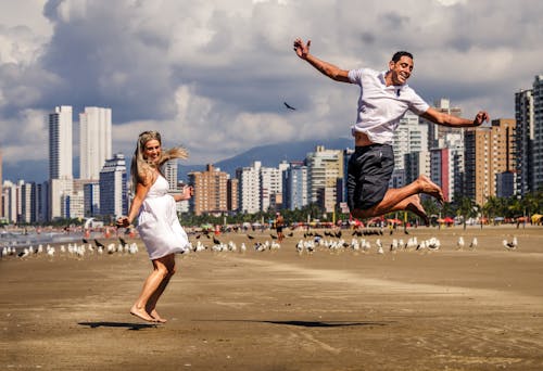 Photo of a Man and A Woman Jumping