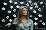 这幅肖像宁静地描绘了一位坐在户外盛开鲜花中的女人