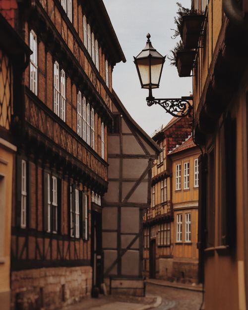 Free Explore the historic charm of Quedlinburg's medieval architecture in this narrow, atmospheric street view. Stock Photo