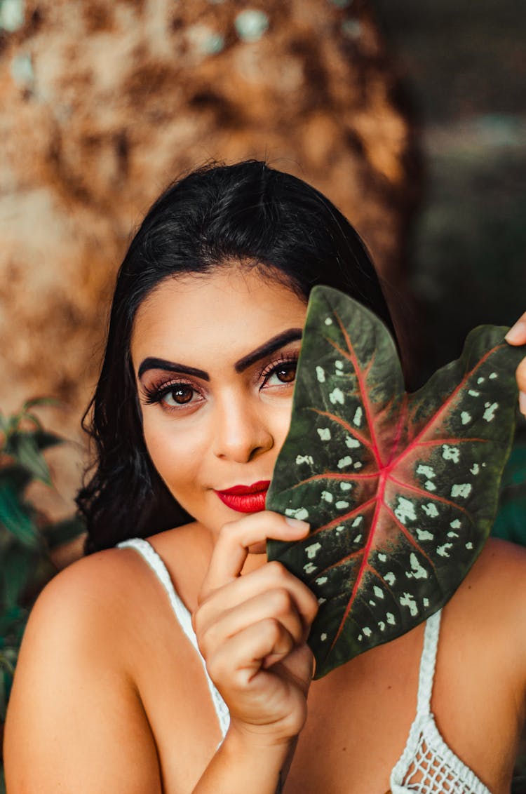 Close-up Photo Of Woman Holding Up A Taro Leaf 