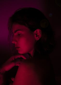 一个女人的时尚肖像，在喜怒无常的红色灯光下显得格外突出，呈现出艺术与戏剧性的效果