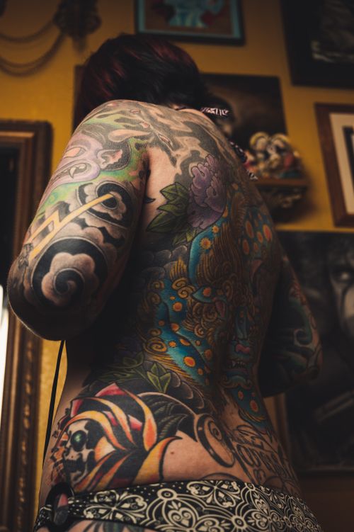Free Colorful tattooed back of a woman in a tattoo studio, showcasing vibrant designs and artistry. Stock Photo