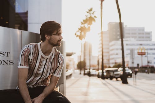 Man Sitting on the Park While Looking on His Left Side