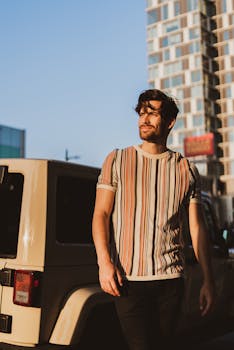 一个男人在温暖的傍晚阳光下漫步的都市休闲时尚肖像