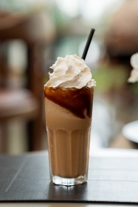 Iced blended coffee topped with whipped cream and a straw — photo by Lucas Durães on Pexels