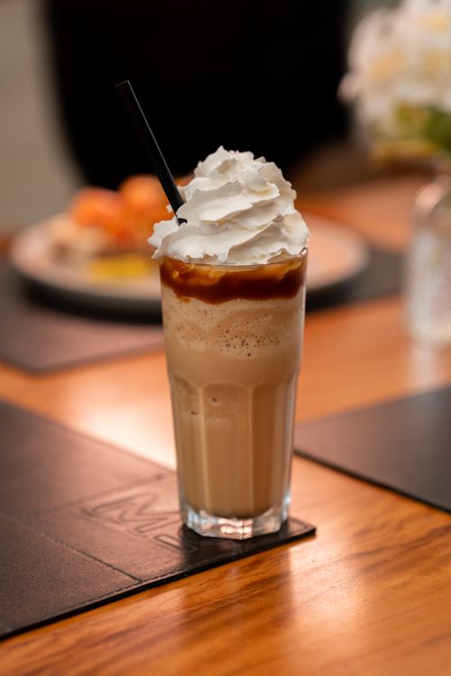 Free Tall glass of iced coffee with whipped cream and caramel, perfect for refreshment. Stock Photo