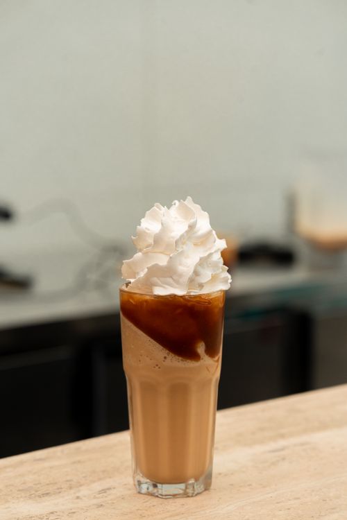 Free Refreshing iced coffee topped with whipped cream in a tall glass, perfect for caffeine lovers. Stock Photo