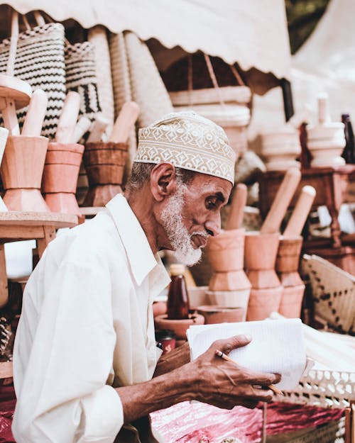 Man Sitting in Front of Handicraft Goods