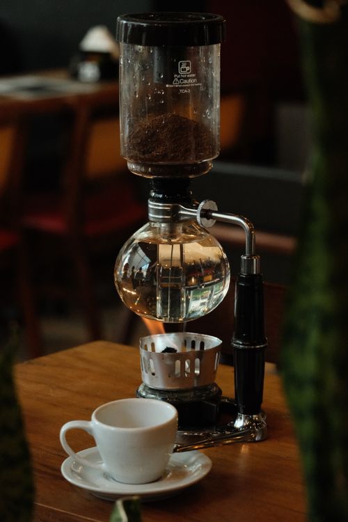 Free Stylish coffee brewing scene at a Rio de Janeiro café showcasing a syphon coffee maker and cup. Stock Photo