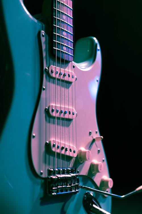 Free Detailed view of a classic electric guitar against a dark backdrop, emphasizing strings and body. Stock Photo