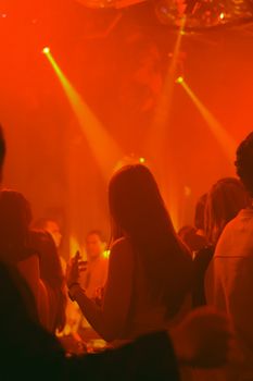 A lively nightclub scene with people dancing and vibrant red lighting, capturing nightlife energy.