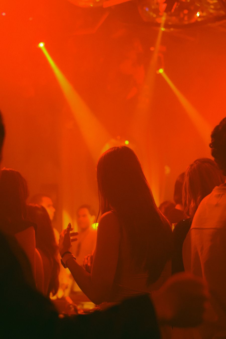People dancing in a club under coloured light — photo by Jos Peñarán on Pexels