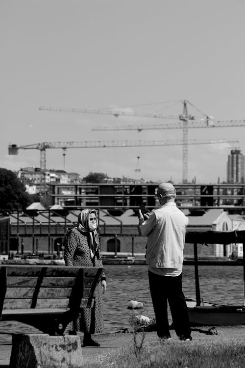 A man and woman standing on a bench near a construction site