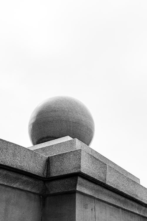 A black and white photo of a ball on top of a building
