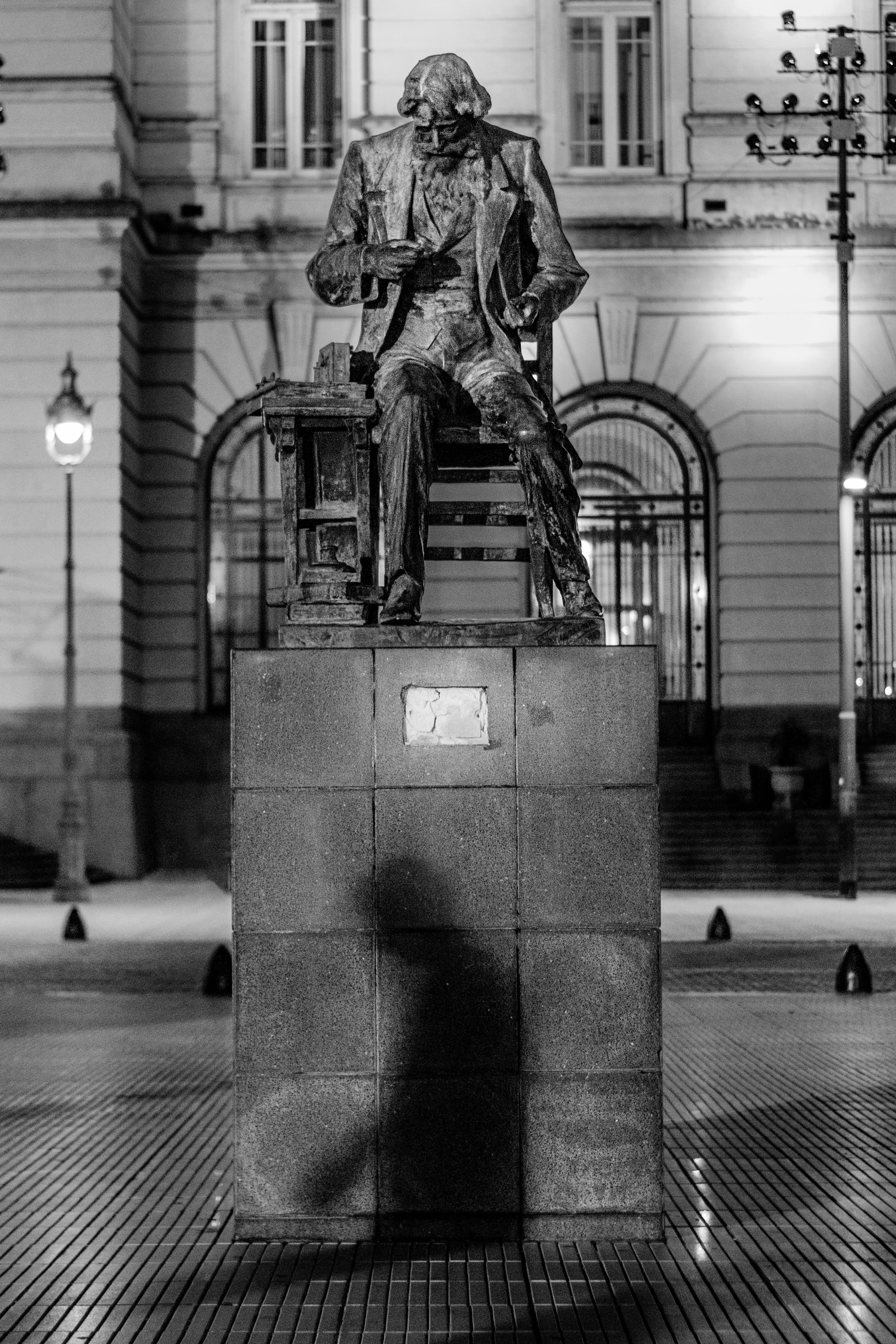 Monochrome photo of Samuel Morse statue in Buenos Aires captured at night with architectural background.