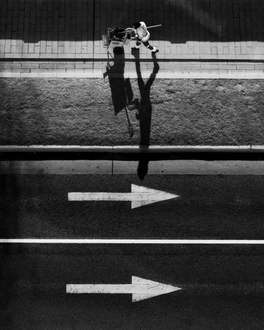 Black and white aerial photo of a street cleaner walking in Buenos Aires, Argentina.