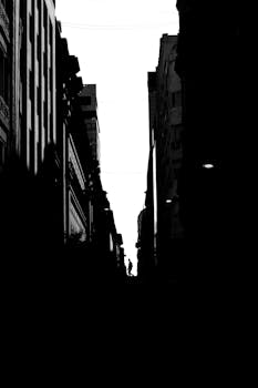 Black and white silhouette of a pedestrian on a Buenos Aires city street, creating a dramatic urban scene.