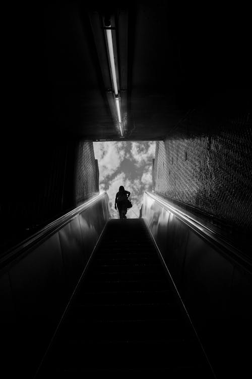 A person walking down an escalator in a tunnel