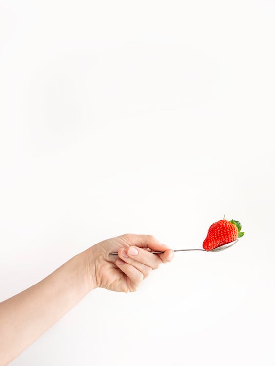 Person Holding Spoon With Strawberry