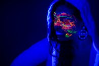 一位女性的肖像在紫外线下涂着发光的霓虹灯油漆，创造出未来派的效果