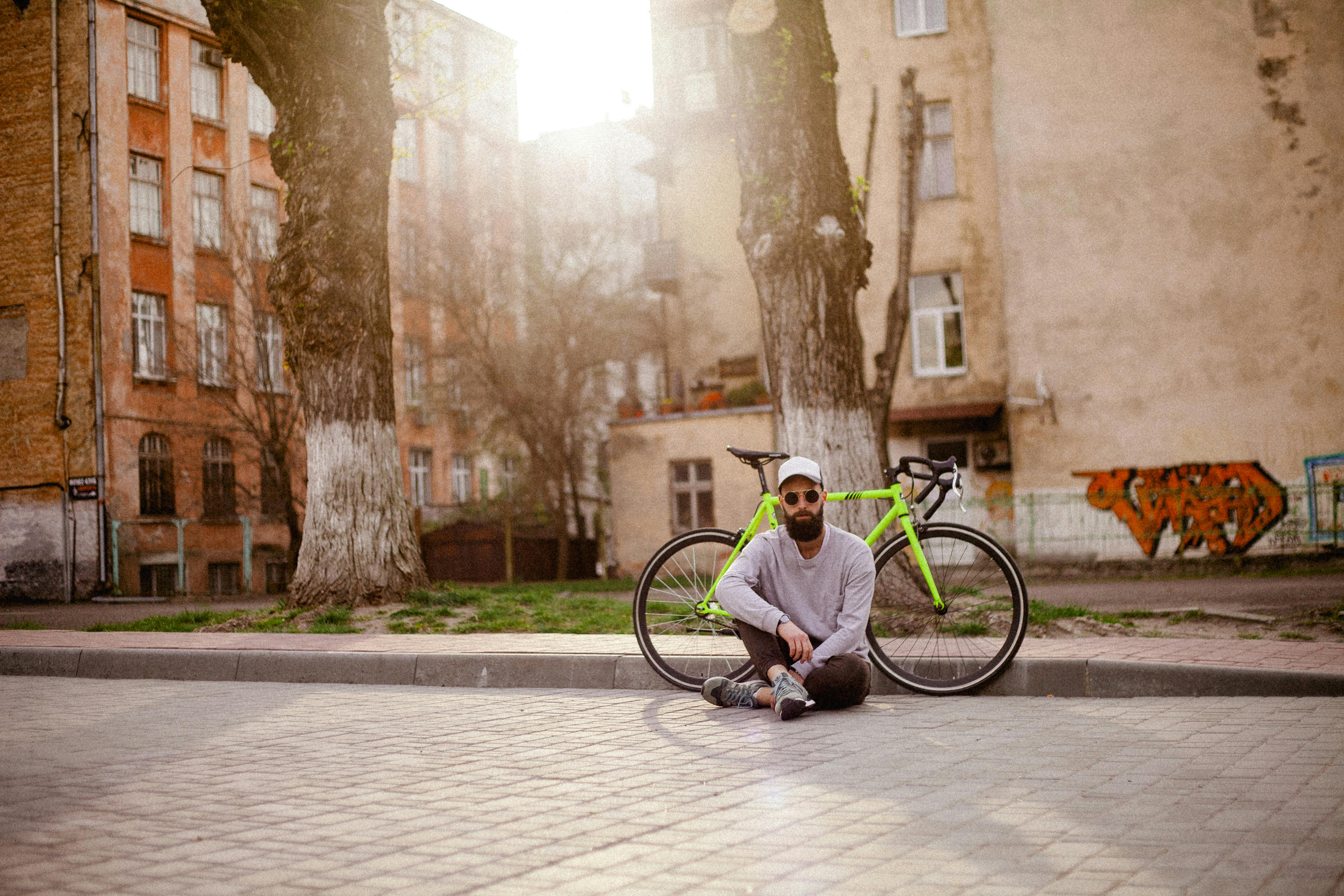 一个男人悠闲地骑着自行车，穿行在阳光温暖的城市街道上