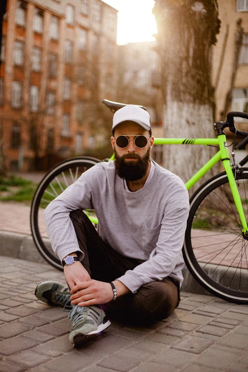 Foto Dell'uomo Seduto Vicino Alla Bici