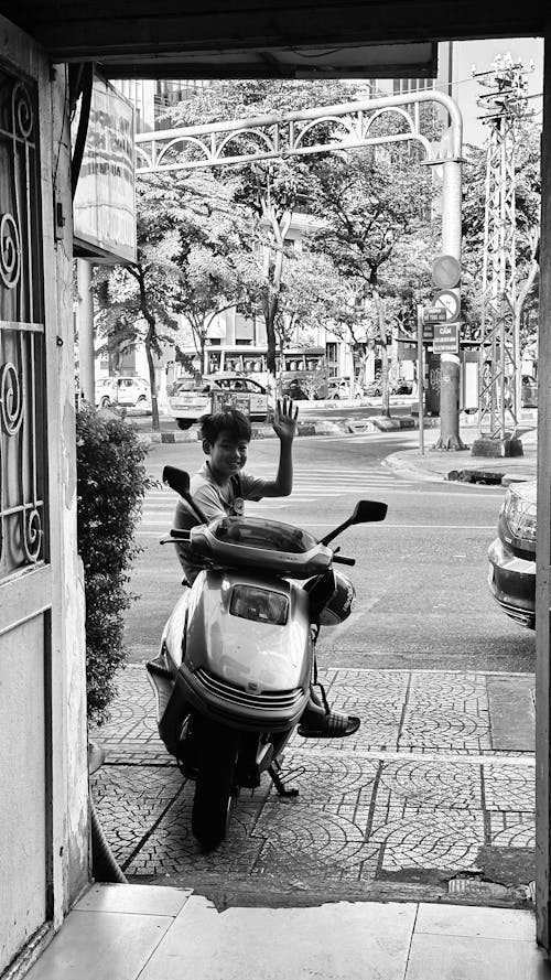A man is sitting on a scooter in front of a door